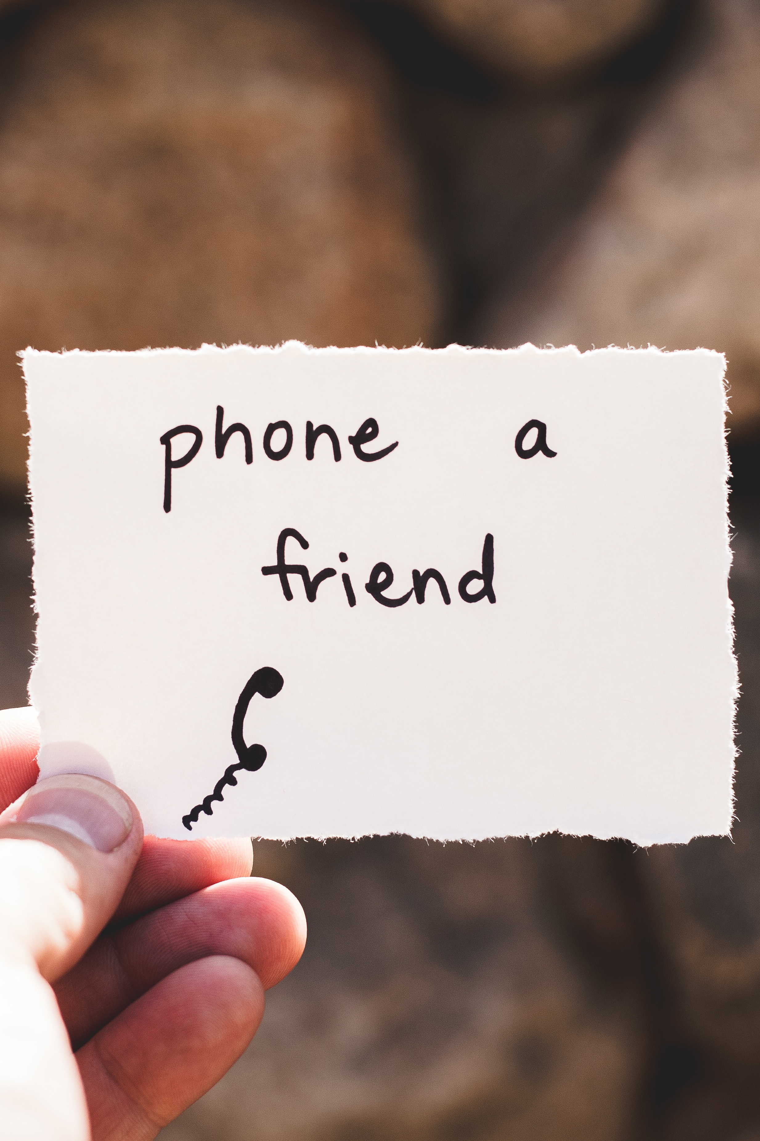 card in a hand reads phone a friend